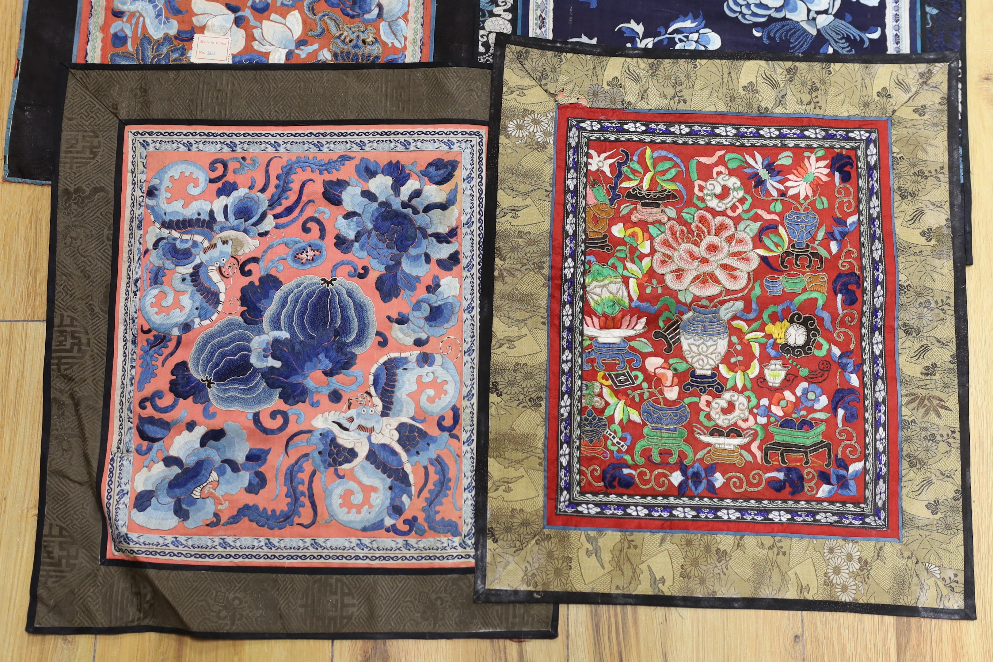 Six panels of Chinese silk embroidered mats, all using mixed stitches including Beijing knot, all bordered with silk brocade, largest 35 x 40cm